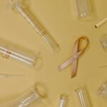 ribbon representing breast cancer amidst test tubes