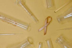 ribbon representing breast cancer amidst test tubes
